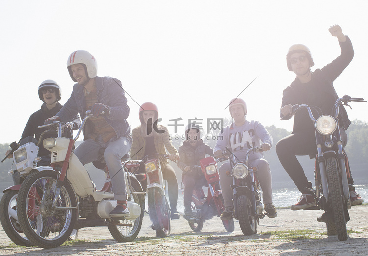 一群朋友在土路上骑着轻便摩托车