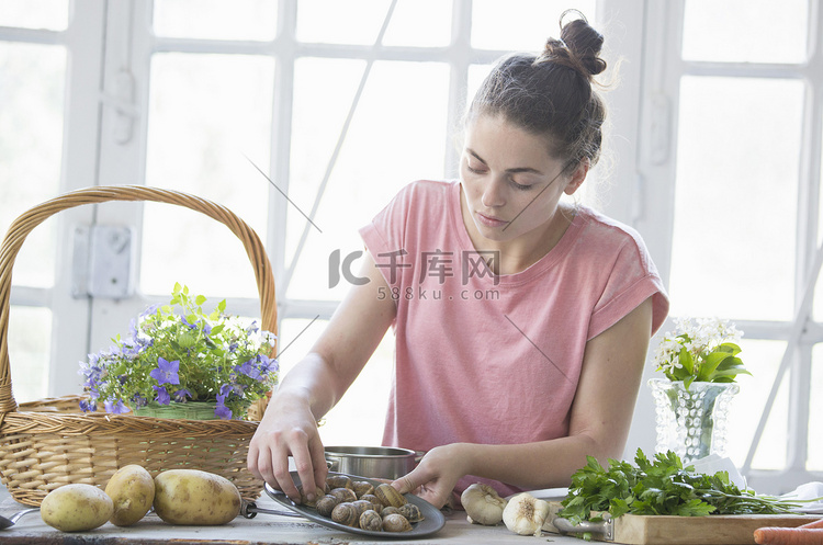 年轻女子在厨房柜台前准备蜗牛意