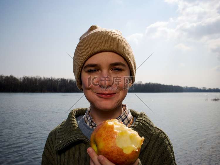 河边的男孩拿着苹果