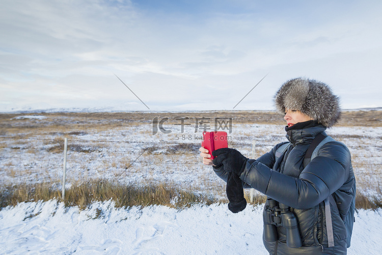 冰岛一名成年女子在积雪覆盖的田