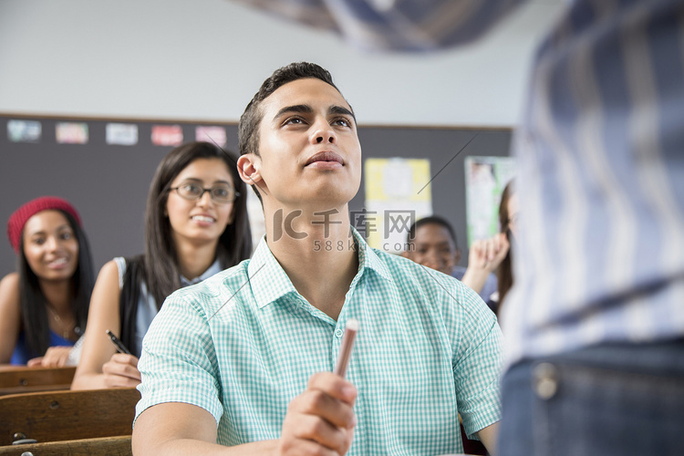 男生在课堂上听老师讲课