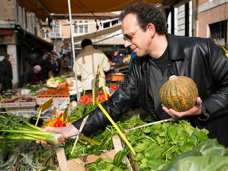 一名男子在市场挑选蔬菜