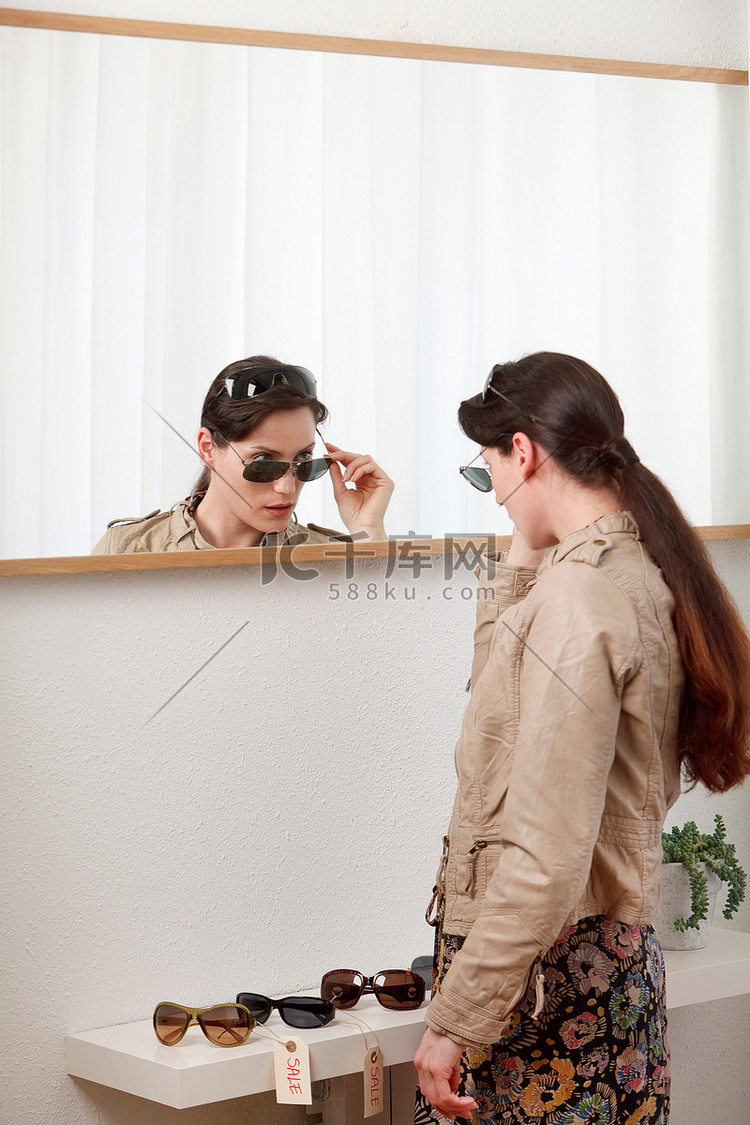 女人在镜子里试戴太阳镜