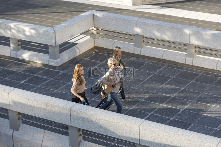 三名成年女性走过高架人行道
