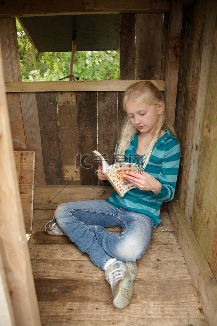 年轻女孩在树屋里看书