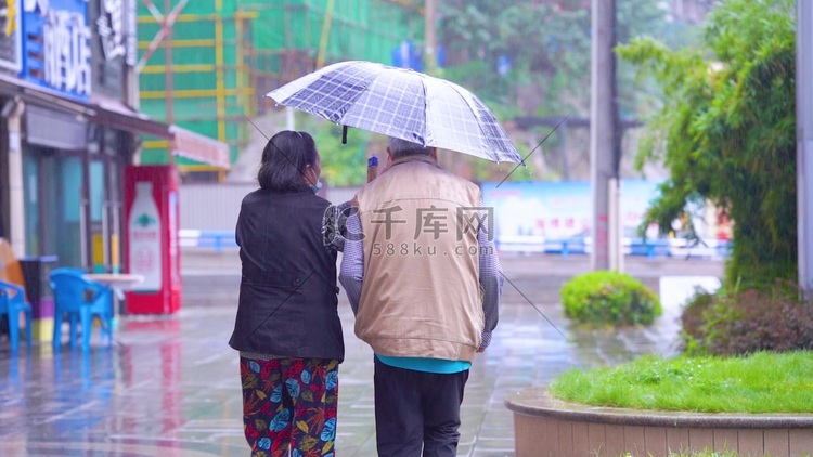 实拍下雨天撑伞行走的老人背影