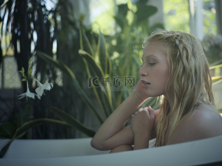 裸体的年轻女子在浴缸里放松在长