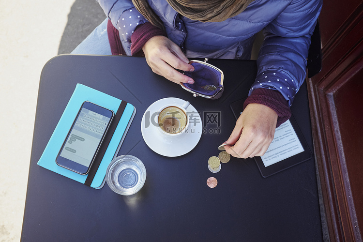 中年妇女在路边咖啡馆数欧元硬币