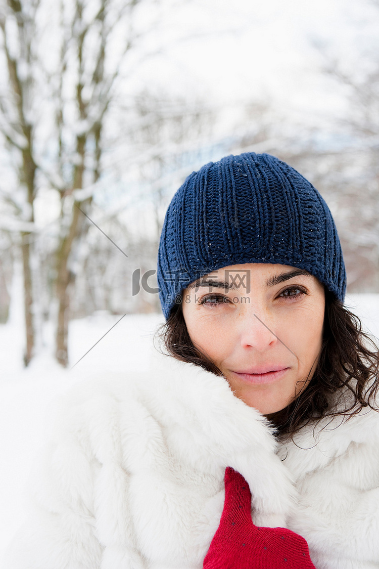 白雪覆盖的树林里的女人看着摄像