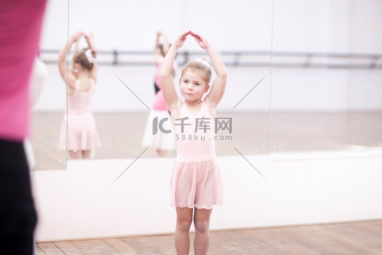 年轻芭蕾舞演员在舞蹈室里摆姿势
