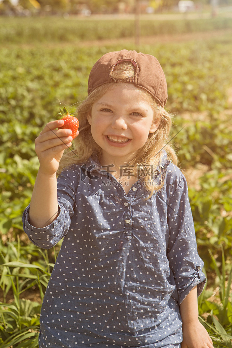 拿着新鲜采摘的草莓的女孩