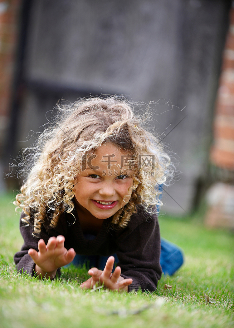 年轻女孩在草地上向镜头爬行