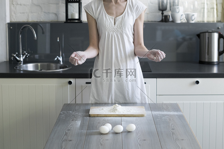 妇女在厨房餐桌上用鸡蛋和面粉烘