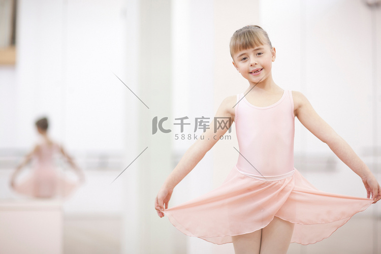 一位年轻的芭蕾舞女演员举着裙子