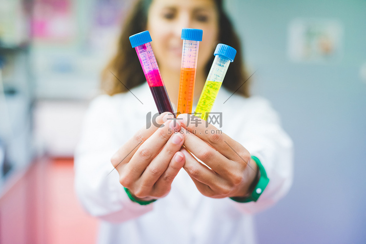 女科学家手持三种不同荧光染料的
