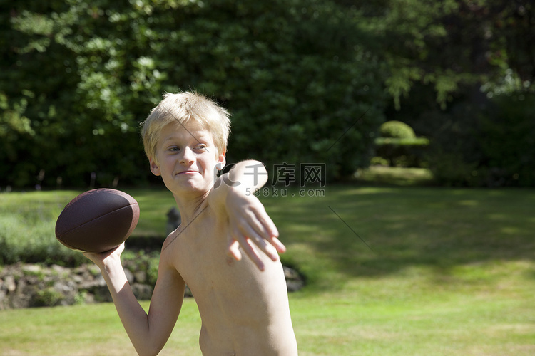 花园里的男孩在扔橄榄球