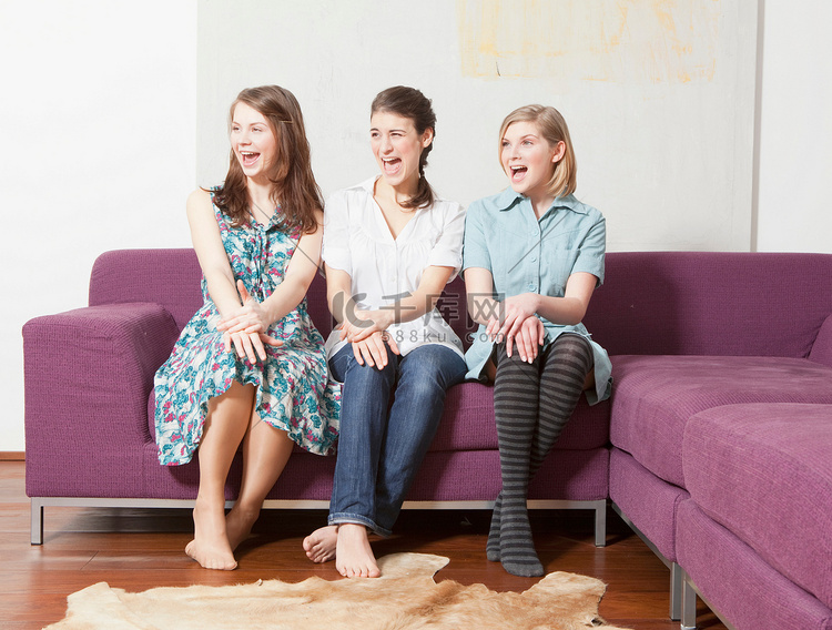 三个女人坐在沙发上尖叫