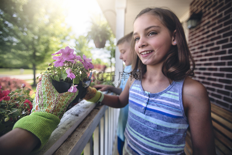 手戴园艺手套将植物交给男孩和女