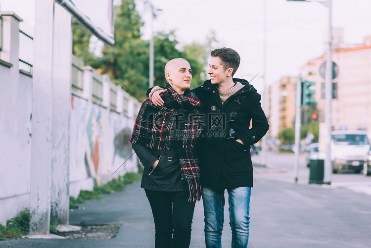 年轻的女同性恋夫妇在城市街道上
