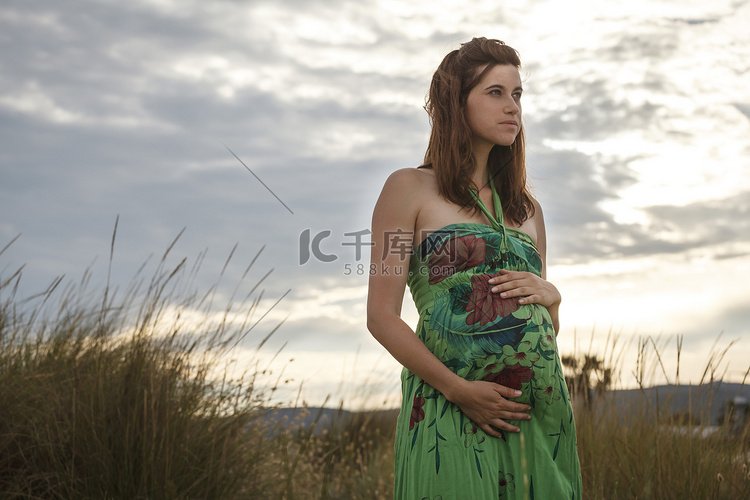 一名孕妇站在田野里