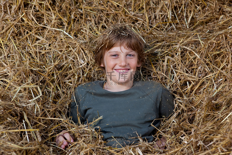 躺在干草里的男孩微笑着