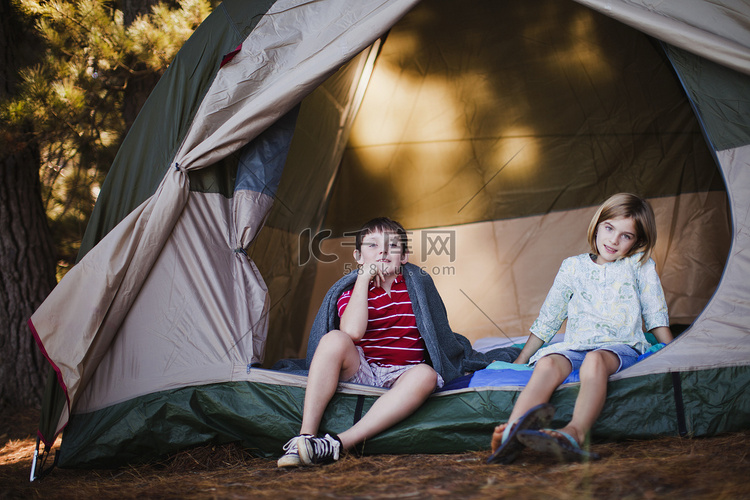 孩子们坐在露营地的帐篷里