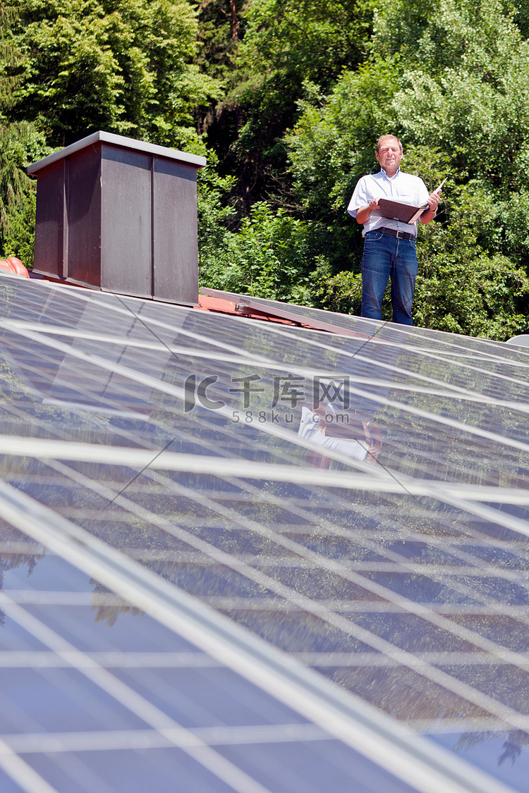 一名男子站在太阳能板屋顶上