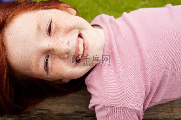 微笑的女孩躺在木头上