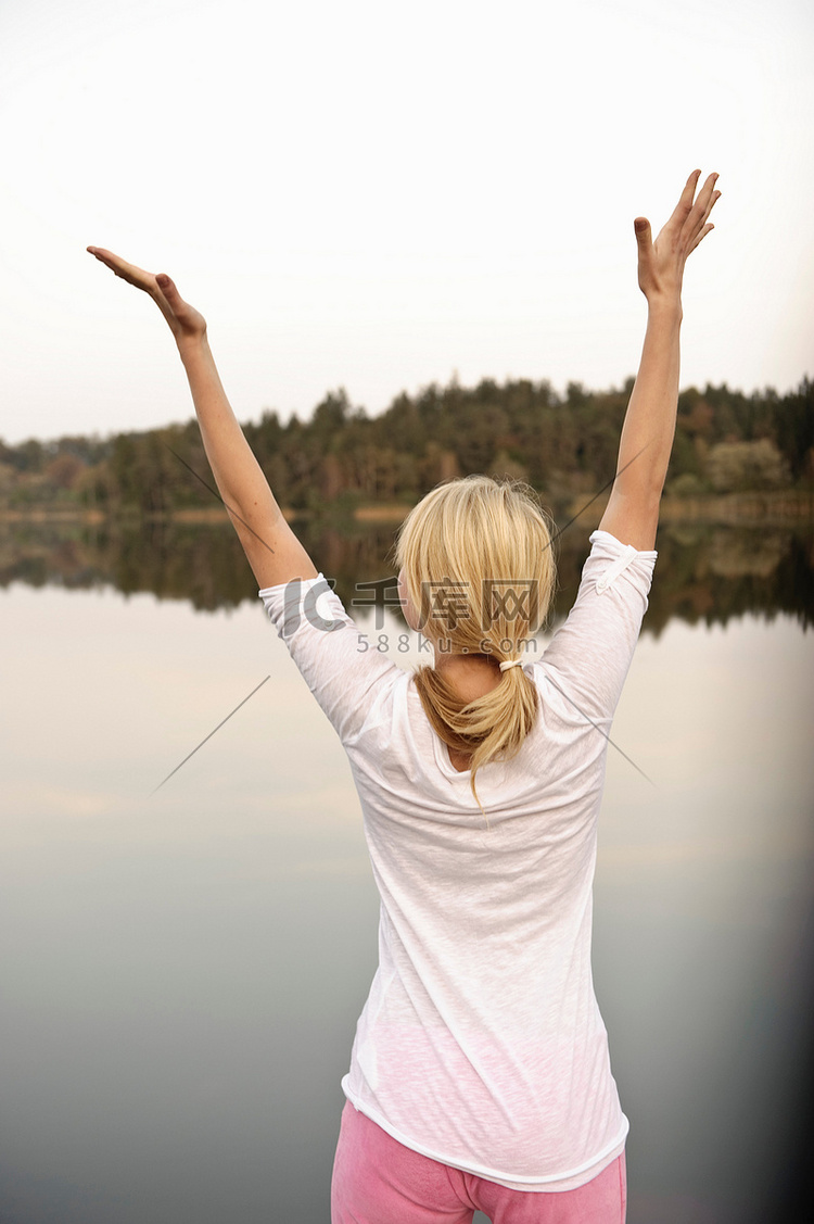 年轻女子在湖边跳舞伸展身体