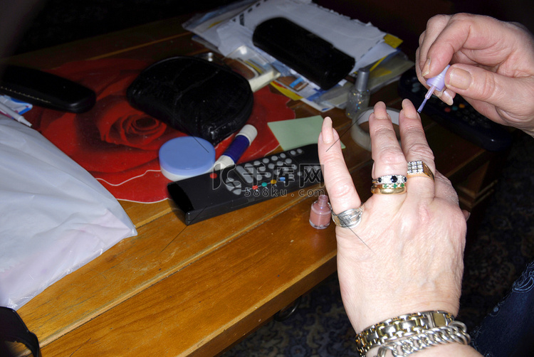 一位老妇人用指甲油涂指甲