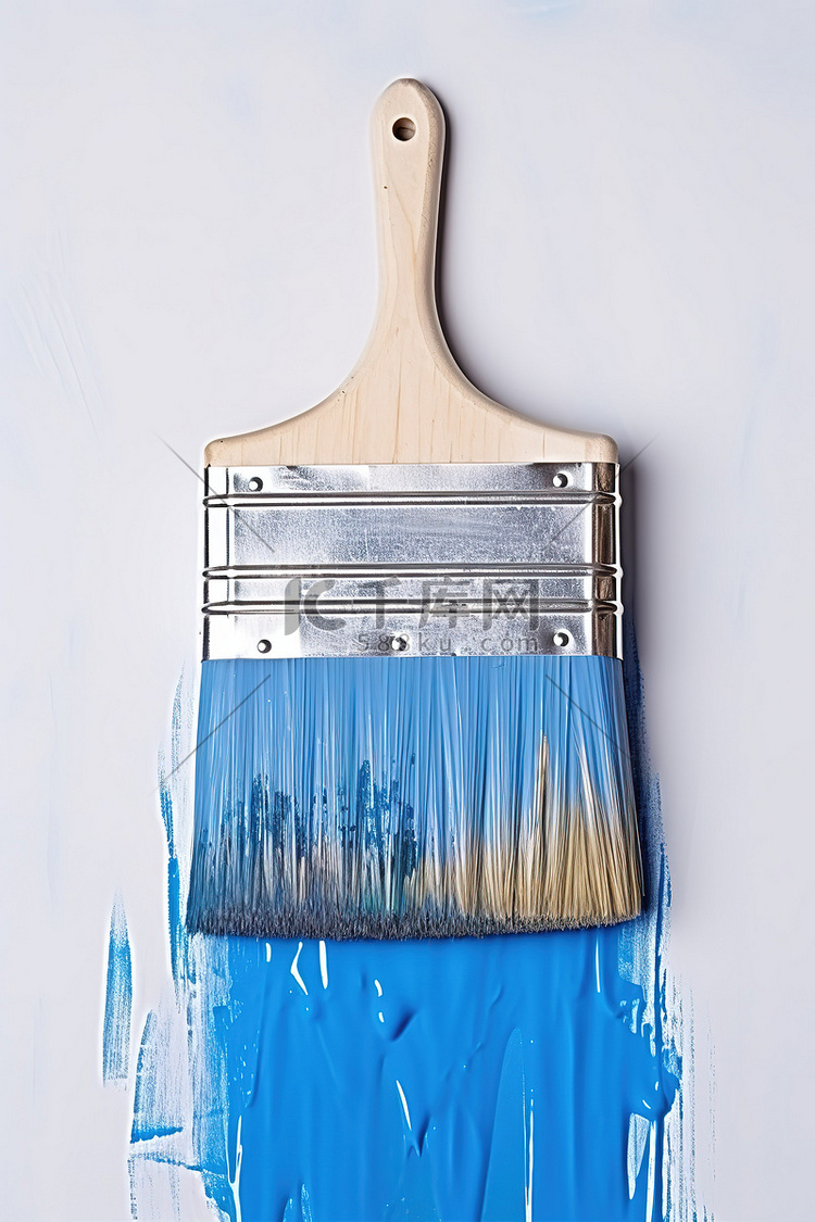 一把旧的蓝色画笔被用来粉刷墙壁
