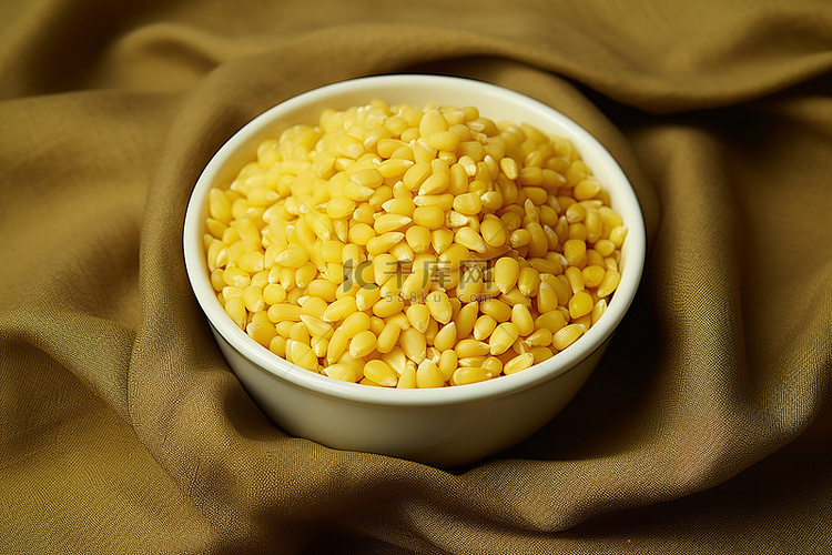 一碗黄色的玉米粒，上面有一些布