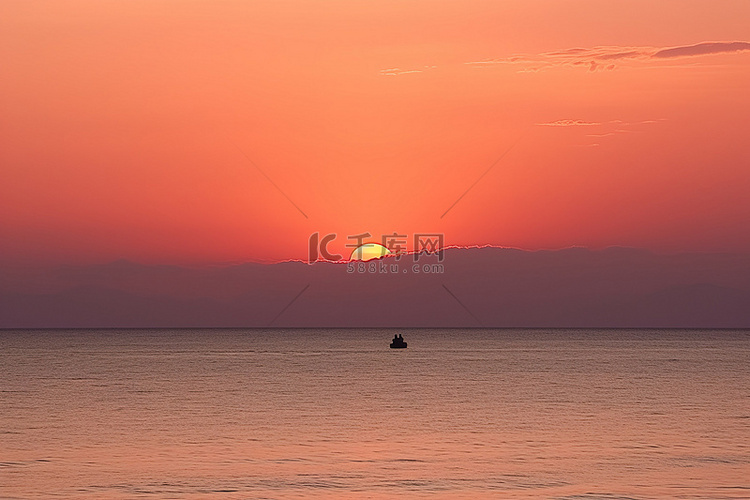 橙色夕阳下两个人在水中骑行