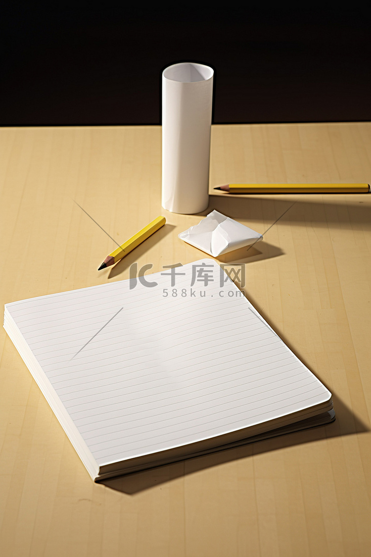 桌上有一本打开的笔记本和一支铅