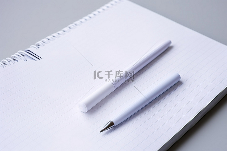 笔记本上的一支白色钢笔和铅笔