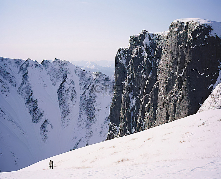 一个男人站在白雪覆盖的悬崖边山