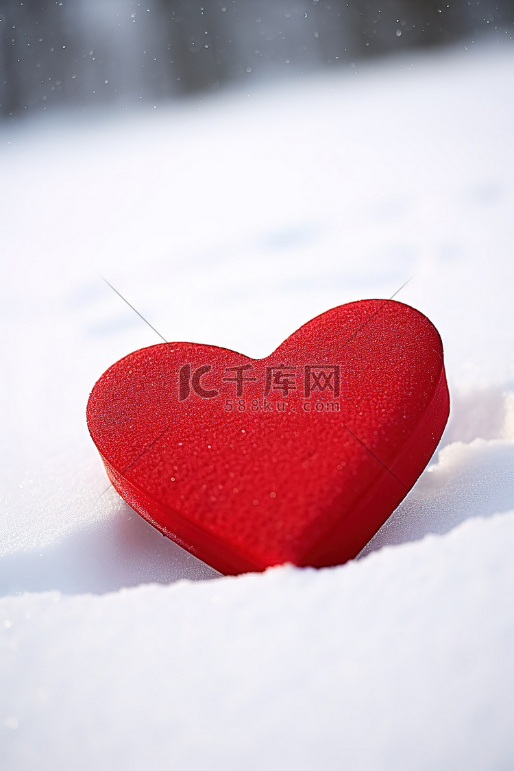 寒冷的白雪上的一个红色心形盒子