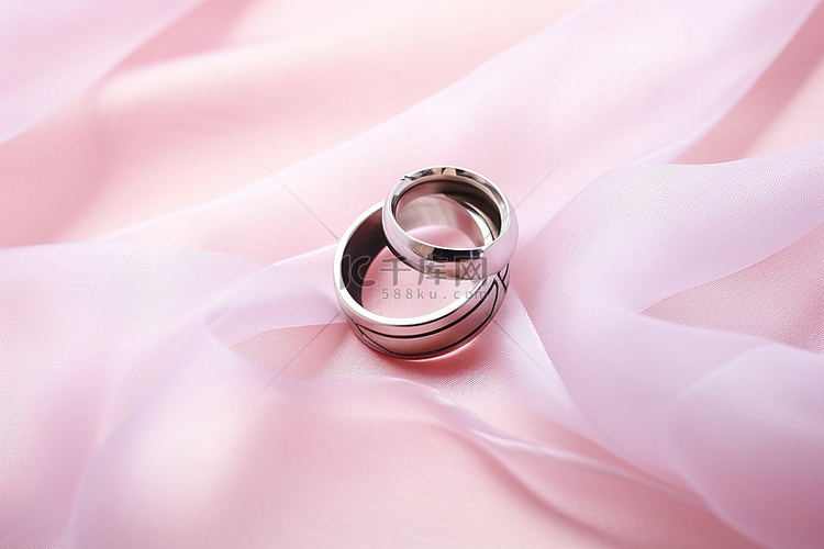 粉色丝绸织物上的结婚戒指免费透
