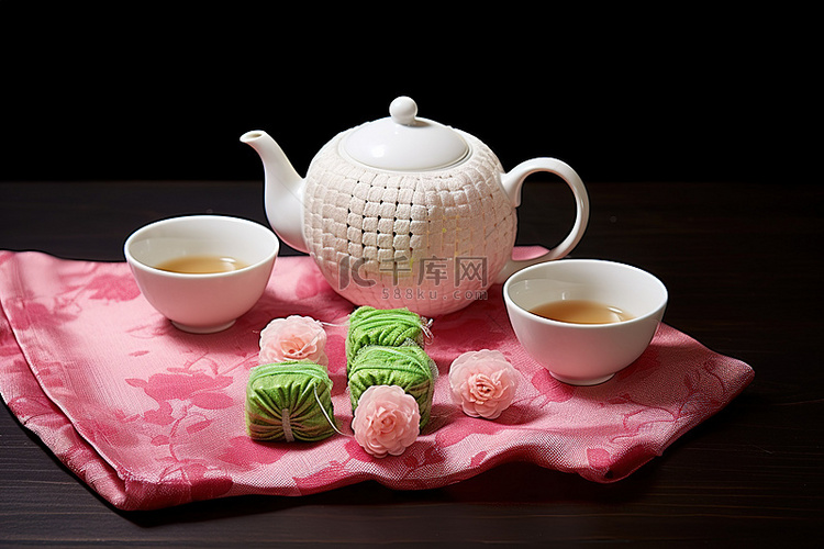 白桌布的茶壶靠近两杯玫瑰和一套