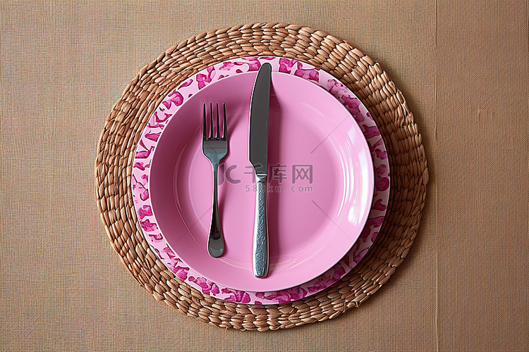 木桌上有塑料叉勺和刀的粉色金属