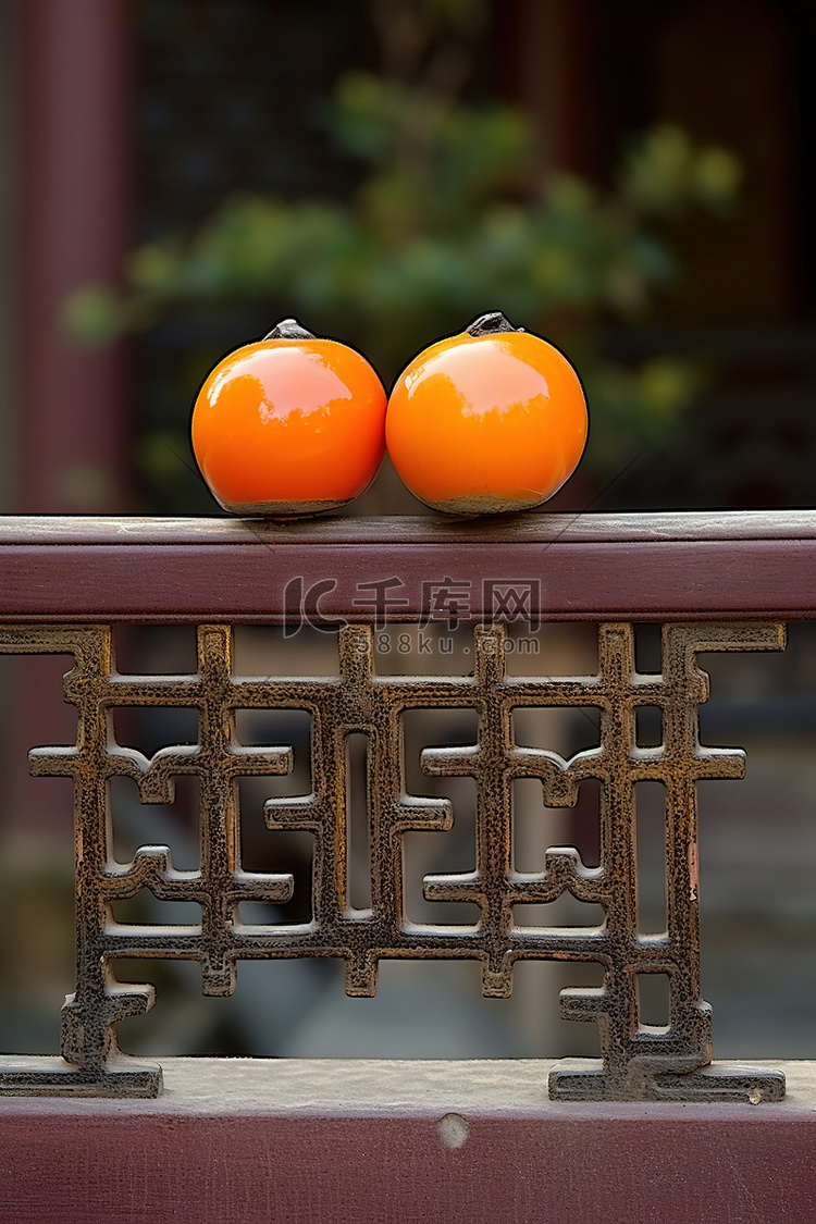 栅栏上坐着三个橙色水果