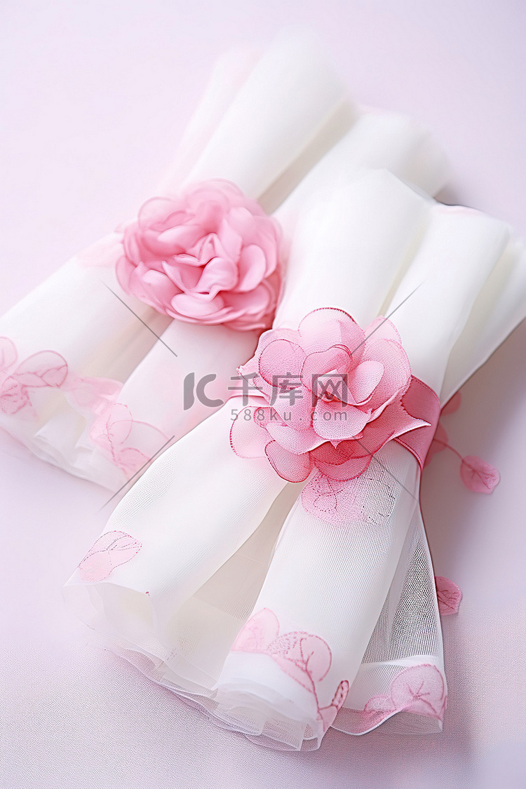 两个带有粉红玫瑰的白色小包装纸
