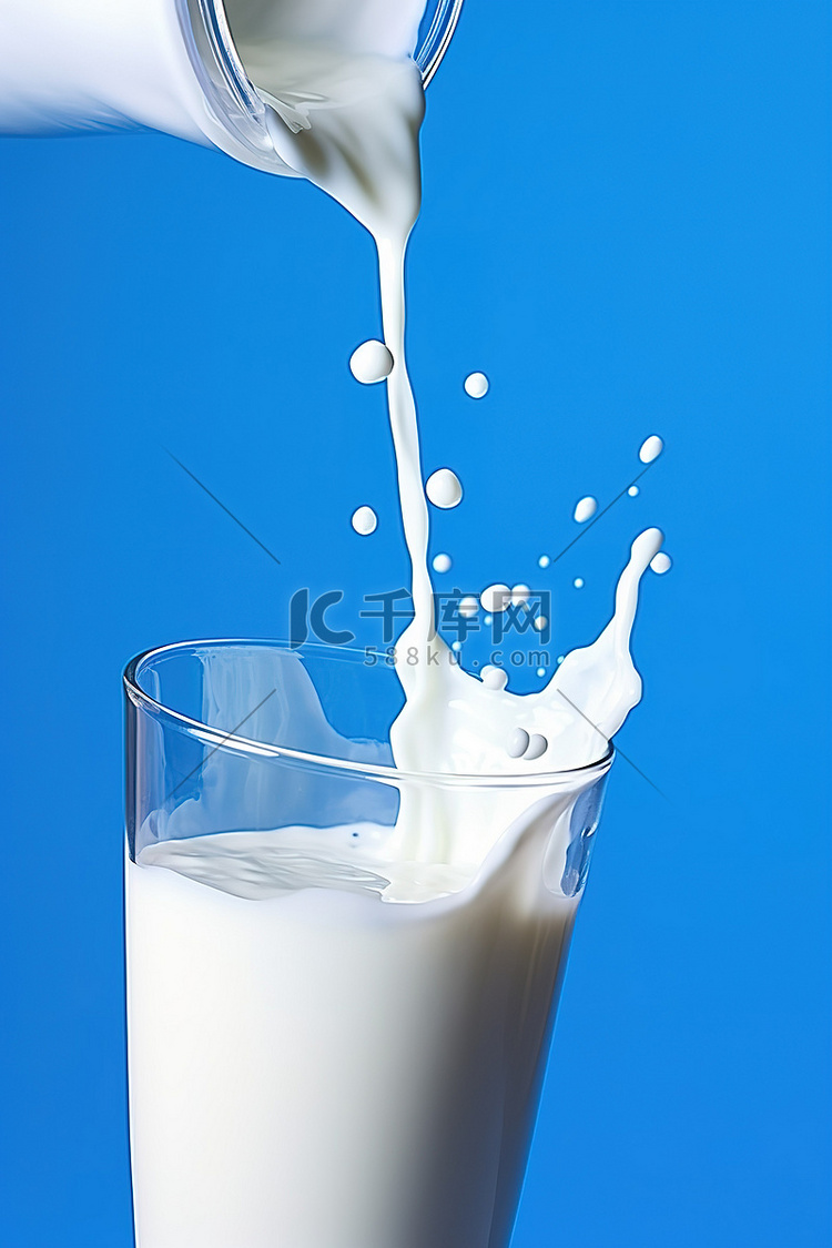 牛奶被倒入蓝色背景的玻璃杯中
