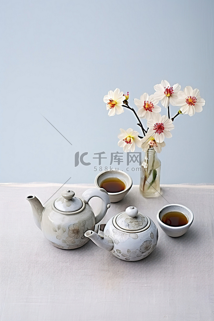 背景前桌子上的两个茶壶和鲜花
