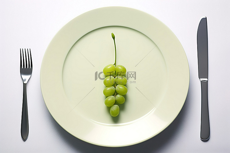 盘子里有一群绿葡萄和叉子