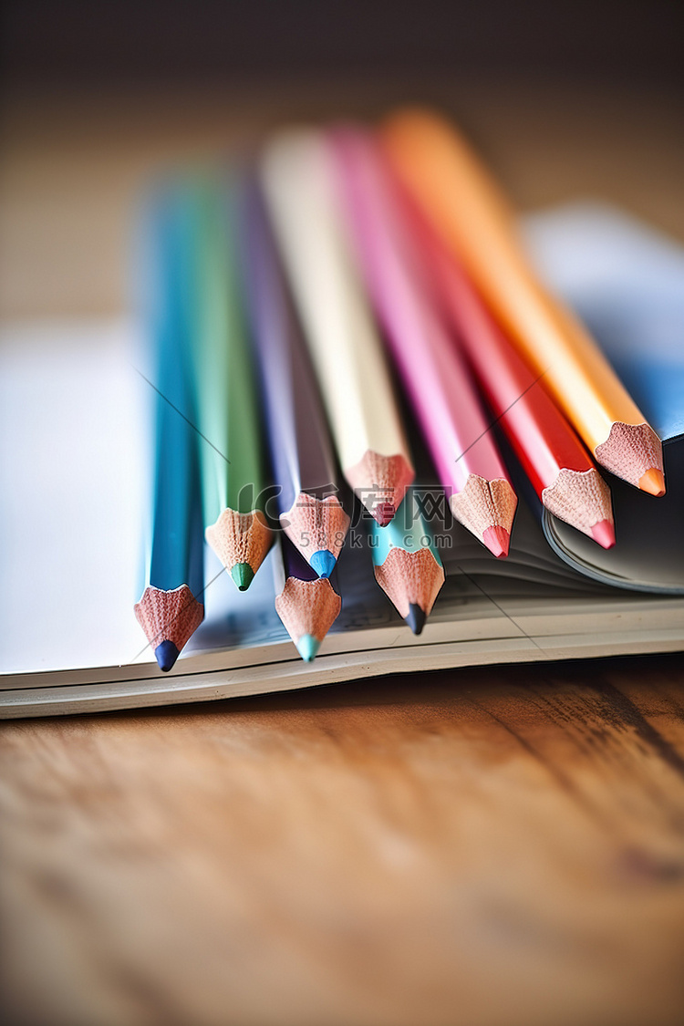 一组彩色铅笔放在桌子上的同一本