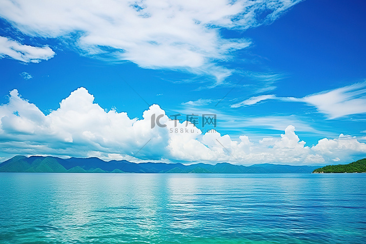 清澈的蓝色水和山景上的白云
