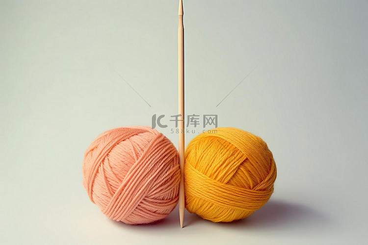 粉色和黄色的毛线球放在两根棍子