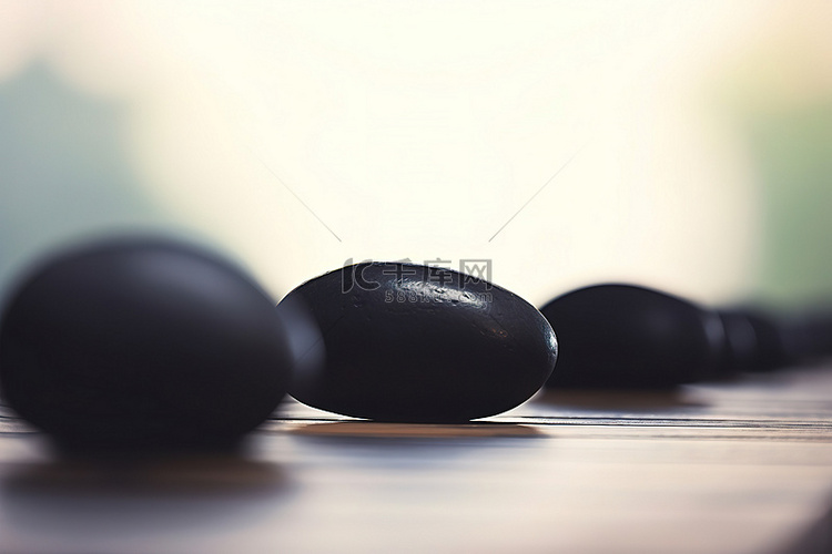 黑色石头排列在桌子上，背景模糊