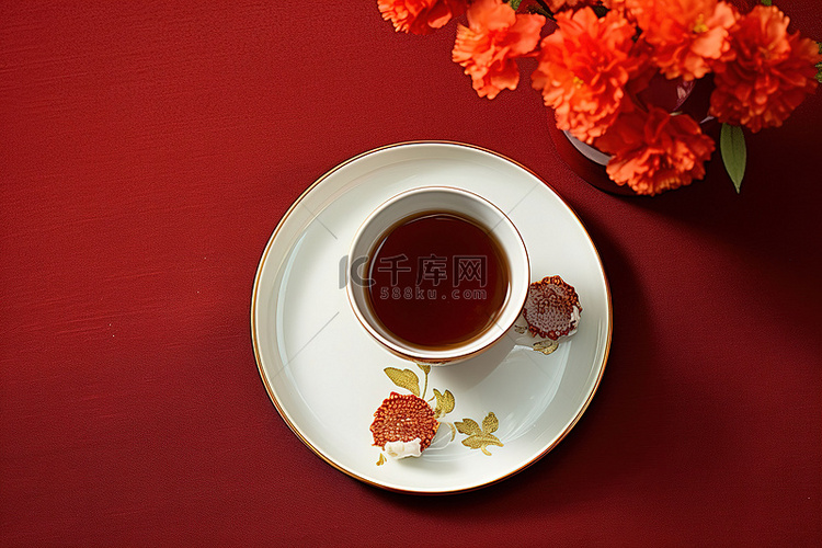 红布上放着中国茶杯和鲜花的盘子